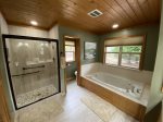 Main floor bathroom offers a jetted garden tub and a separate tile shower 